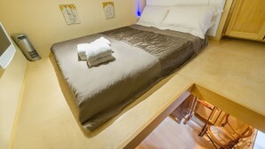 A bedroom with a bed, a bedside table, a chair, and a small balcony. - The Vintage - Fitzrovia - by Frankie Says (London)