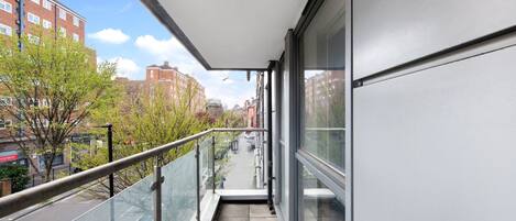 A modern apartment with a balcony overlooking a city street.
