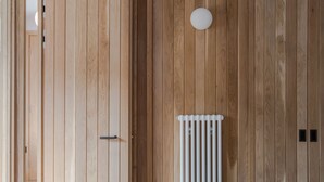 A room with wooden panel walls, a white radiator, and a door with a handle. - Casa Emilio - Soho - by Frankie Says (London)