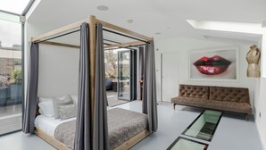 Un dormitorio moderno con cama con dosel, techo de cristal y vistas al exterior.
