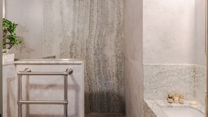 A bathroom with a marble shower, a towel rack, and a shelf with toiletries. - Casa Peppino - Soho - by Frankie Says (London)