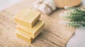 Three stacked bars of soap on a burlap cloth.