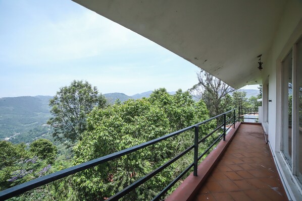 A balcony with a view of a mountainous landscape. - Samrakshitha Suits  (Kotagiri)