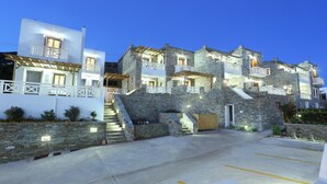 A multi-story building with stone walls and balconies, featuring a staircase leading to the upper floors. - Aithra Andros (Andros)