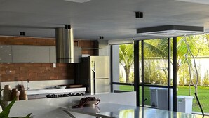 Una cocina moderna con una isla grande, electrodomésticos de acero inoxidable y vistas a un jardín exuberante.