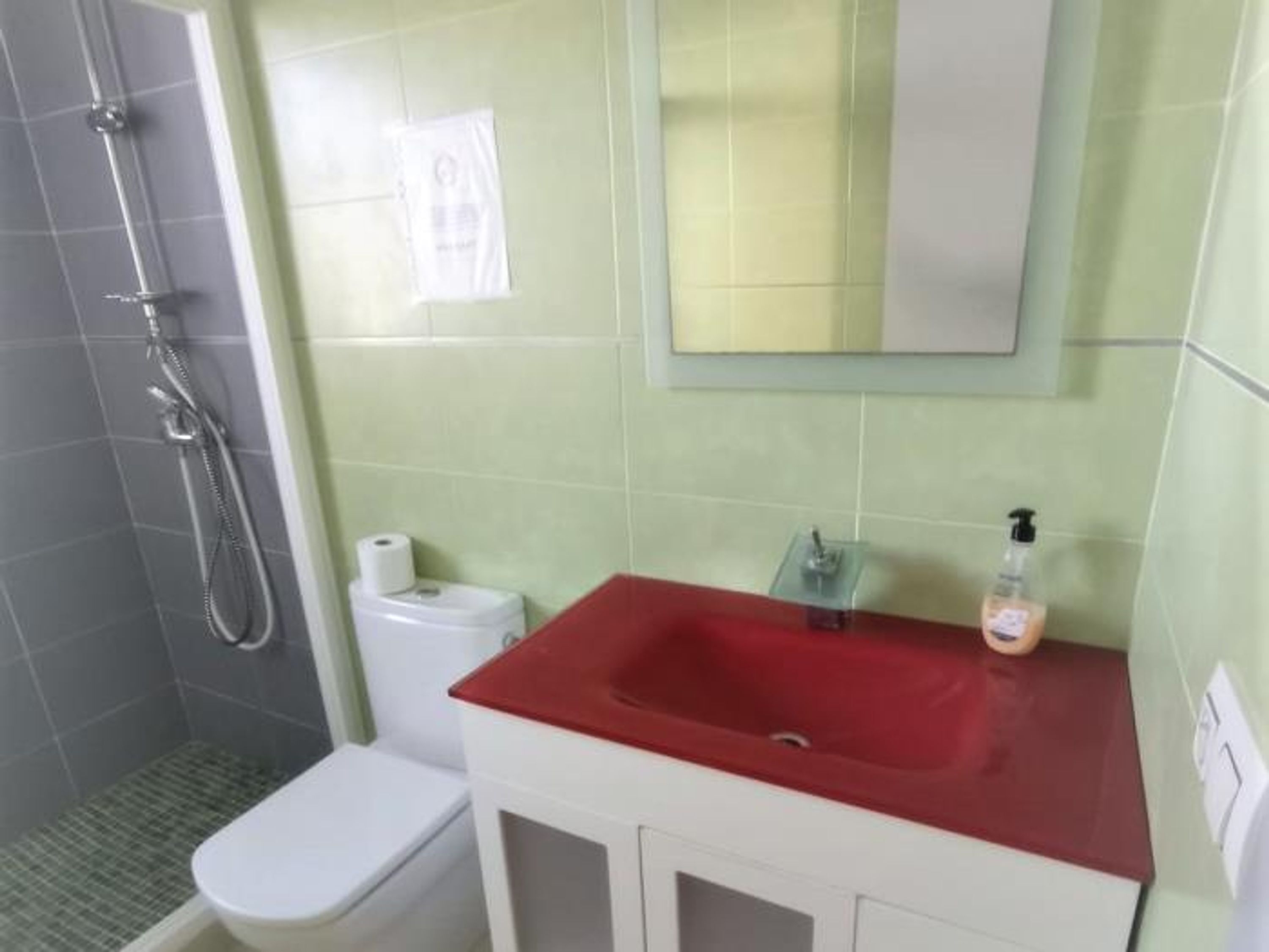 A bathroom with a shower, toilet, and sink.