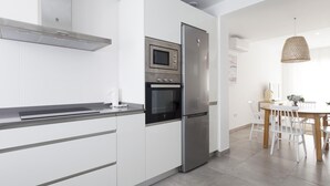 A modern kitchen with white cabinetry, a stainless steel refrigerator, a built-in oven, and a microwave. - Selecta I 32321 in Conil de la Frontera (Conil de la Frontera)