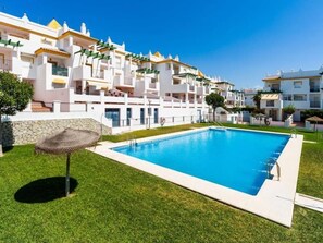 Un hôtel moderne doté d’une piscine, de bâtiments blancs et d’une pelouse bien entretenue.