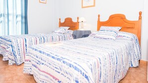 Ein Schlafzimmer mit zwei Einzelbetten, einem Nachttisch, einer Lampe und einem gerahmten Bild an der Wand.