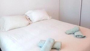 A bed with white bedding and two rolled towels on it. - Apartamento Canela 2536 (Conil de la Frontera)