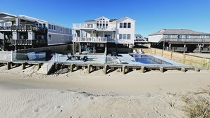 Una propiedad frente a la playa con varios niveles, piscina y terraza de madera.