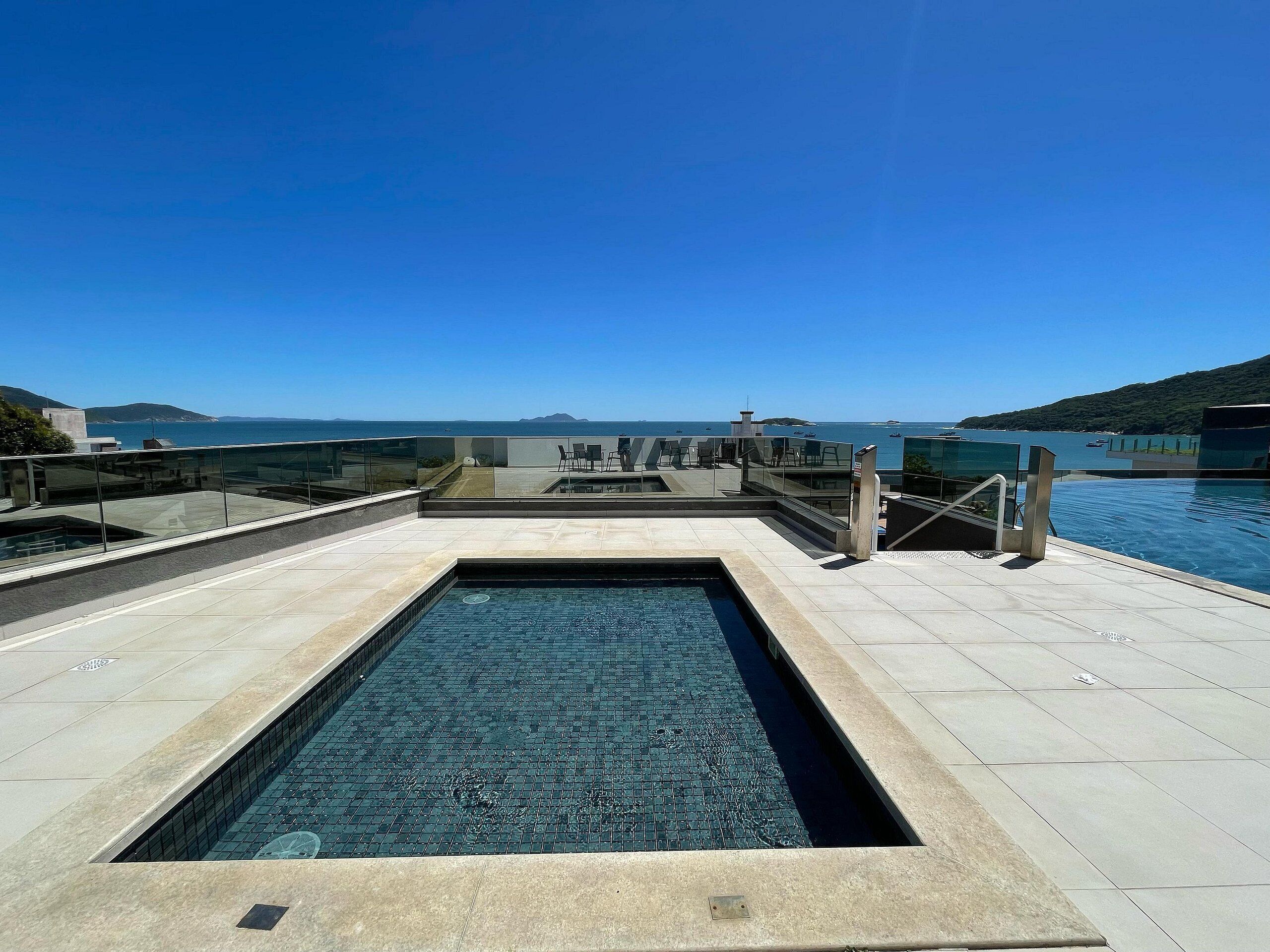 A rooftop pool with a clear view of the sea and distant islands.