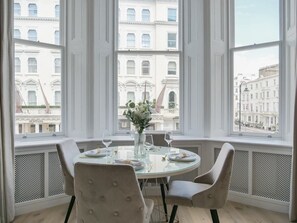 Enjoy meals with a city view from this dining area featuring a round table and comfortable seating for four.