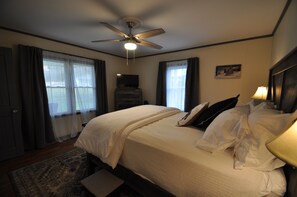 Relax in this inviting space with a large bed, ceiling fan, and TV.