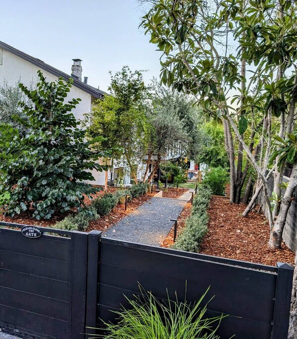 Stroll through the beautifully maintained garden pathway to the entrance of this serene residential property.