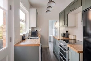 A kitchen with a central island, built-in oven, and a view to the adjacent dining area.
