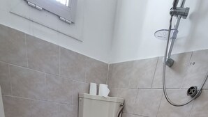 Un baño con inodoro, ducha y lavamanos.