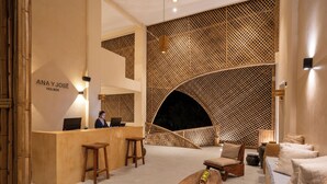 A modern interior with a reception desk, wooden furniture, and unique wall designs. - Ana y Jose Holbox Boutique All Inclusive Hotel (Isla Holbox)