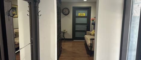Un couloir doté d’un plancher en bois, d’une horloge au mur et d’une porte sur laquelle est apposée une pancarte indiquant « Défense d’entrer ».