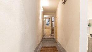 A narrow hallway with a wooden door at the end, a rug on the floor, and a wall-mounted decoration. - Tuscany Dream - Two Bedroom House, Sleeps 3 (Arezzo)