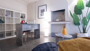 A modern living room with a grey sofa, a coffee table, a bookshelf, and a large green plant. - Tuscany Dream - Two Bedroom House, Sleeps 3 (Arezzo)