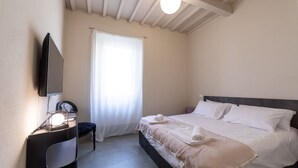 A bedroom with a bed, a desk with a lamp, a chair, and a window with curtains. - Tuscany Dream - Two Bedroom House, Sleeps 3 (Arezzo)