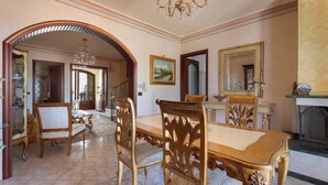 A dining area with a wooden table and chairs, a chandelier, and a fireplace. - Casa Pireddu by BarbarHouse (Castro)