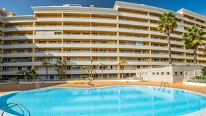 A large swimming pool with a multi-story hotel building in the background. - Lux Garden View by Madeira Sun Travel (Funchal)