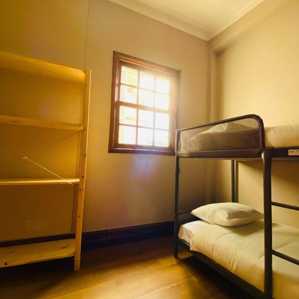 Una habitación pequeña con literas y una ventana.