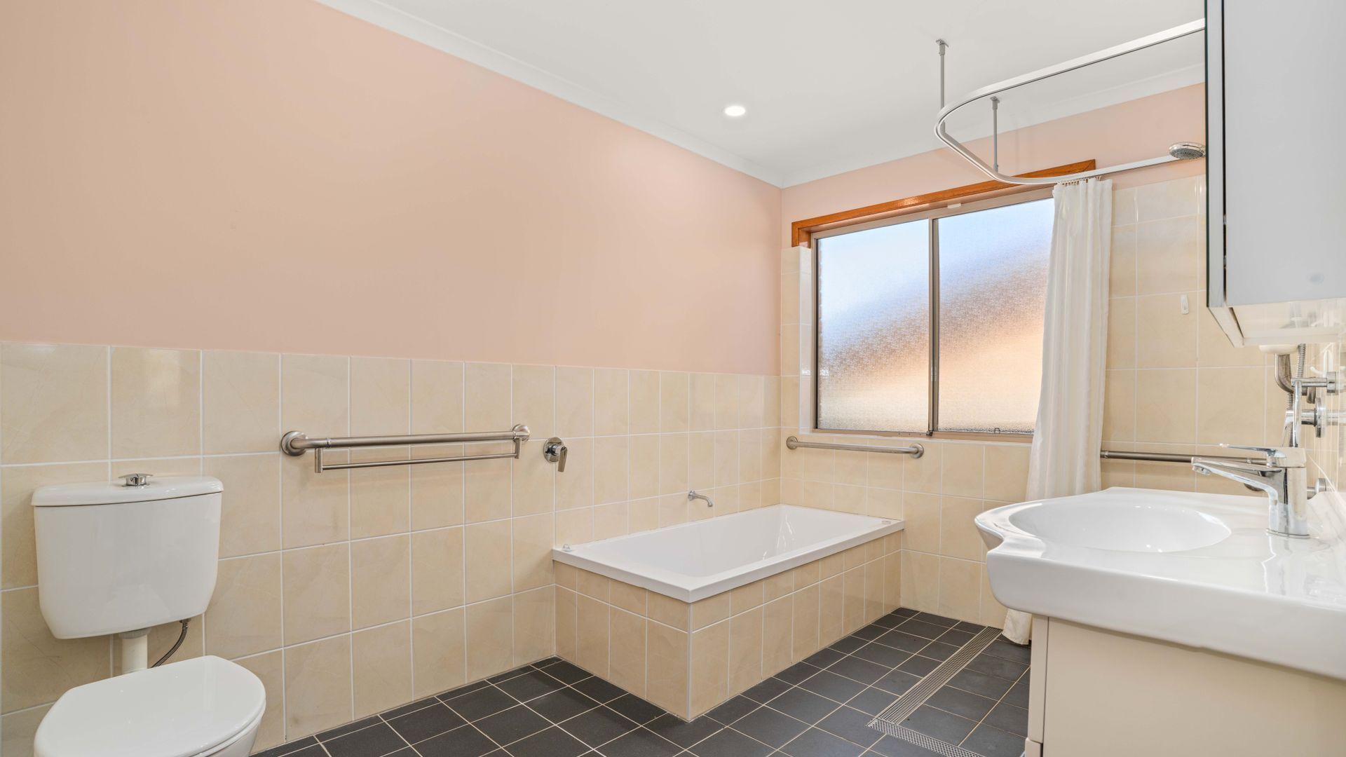 A bathroom with a toilet, bathtub, and sink.