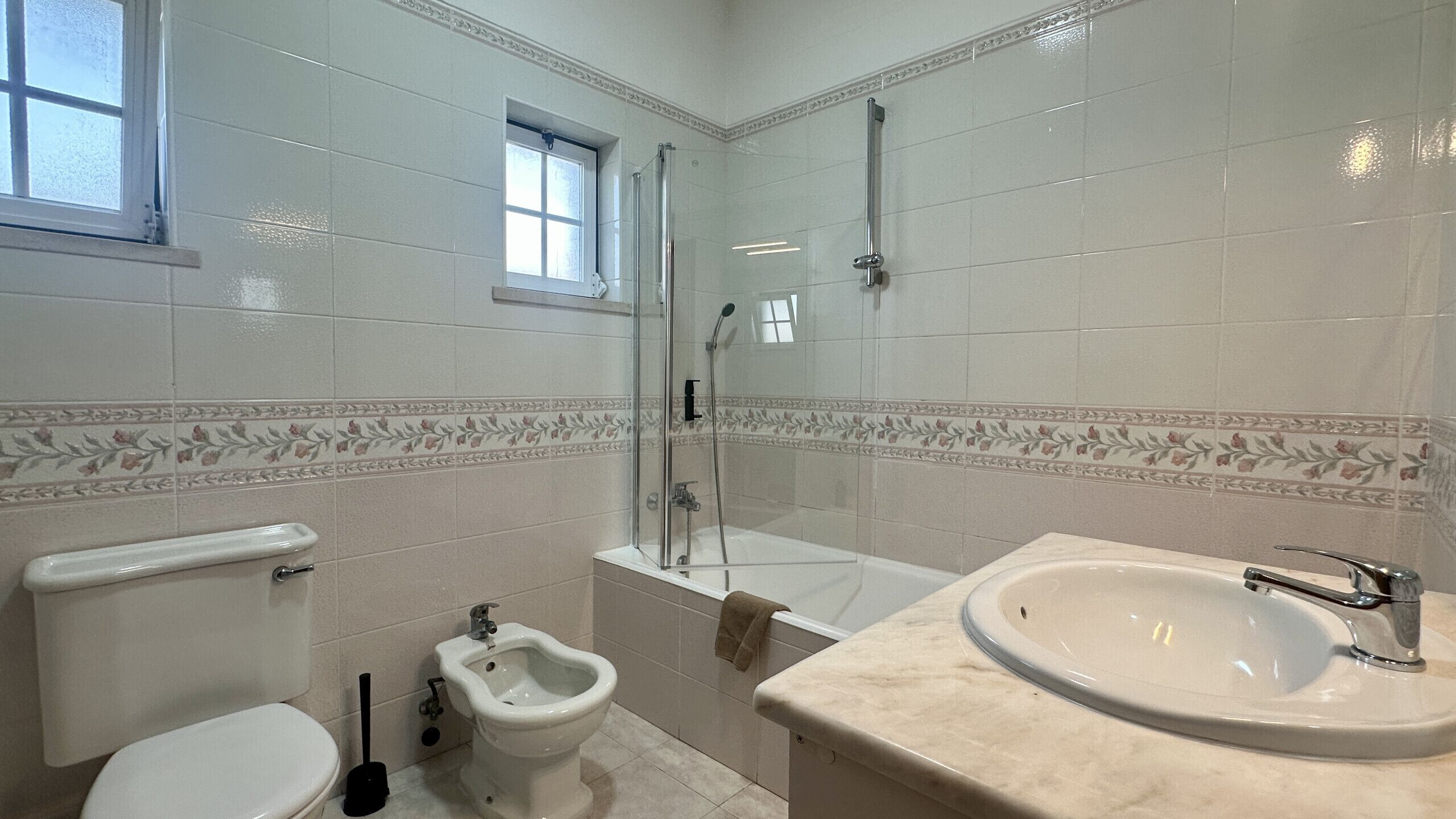 A bathroom with a toilet, bidet, bathtub, and sink.