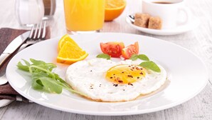 A breakfast plate with an egg, orange, tomato, and greens. - New Abusimble Hotel (Abu Simbel)