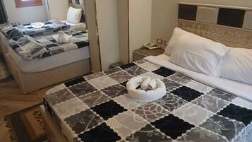Una habitación de hotel con una cama, una mesita de noche con un teléfono y una lámpara de noche.