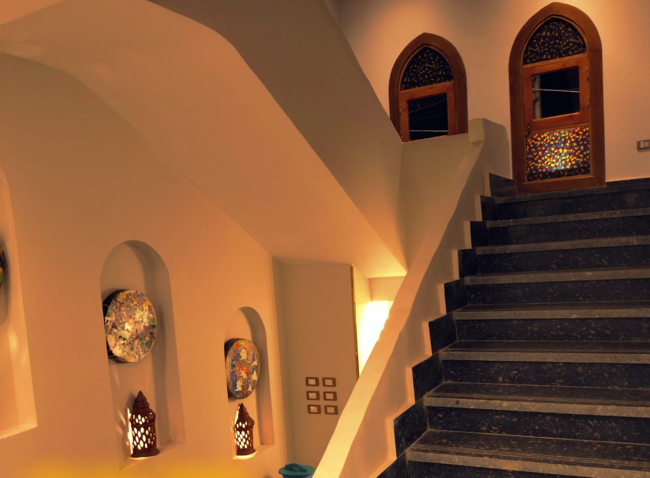Una escalera conduce a una habitación con un letrero que dice 'NEW ABU SIMBEL HOTEL'.