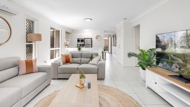 A modern living room with a grey sofa, a coffee table, and a TV on a wooden stand. - Contemporary Chic on CBD Fringe! (Toowoomba)
