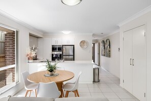 Enjoy meals in this well-equipped kitchen with oven, refrigerator, and dining area.