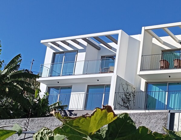 Um edifício moderno de dois andares com varandas e janelas amplas.