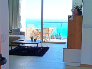 A balcony with a view of the ocean, a sofa, a coffee table, and a plant. - Holiday House Caetano (PONTA DO SOL)