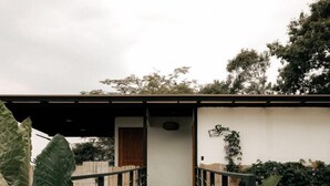 A pathway leading to a building with a wooden door and a small overhang. - Santuario Luxury Ecohotel (Villeta)