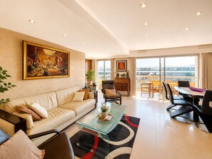 Ein modernes Wohnzimmer mit Sofa, Couchtisch und Essbereich.
