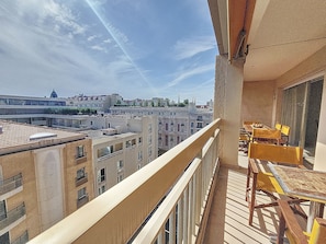 A balcony with a view of a cityscape, including buildings and a dome structure.