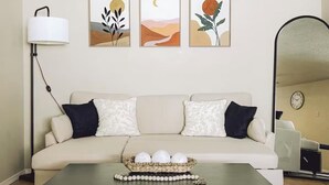 A living room with a sofa, a coffee table, and three framed artworks on the wall. - Casamor - Home in Richland (Richland)
