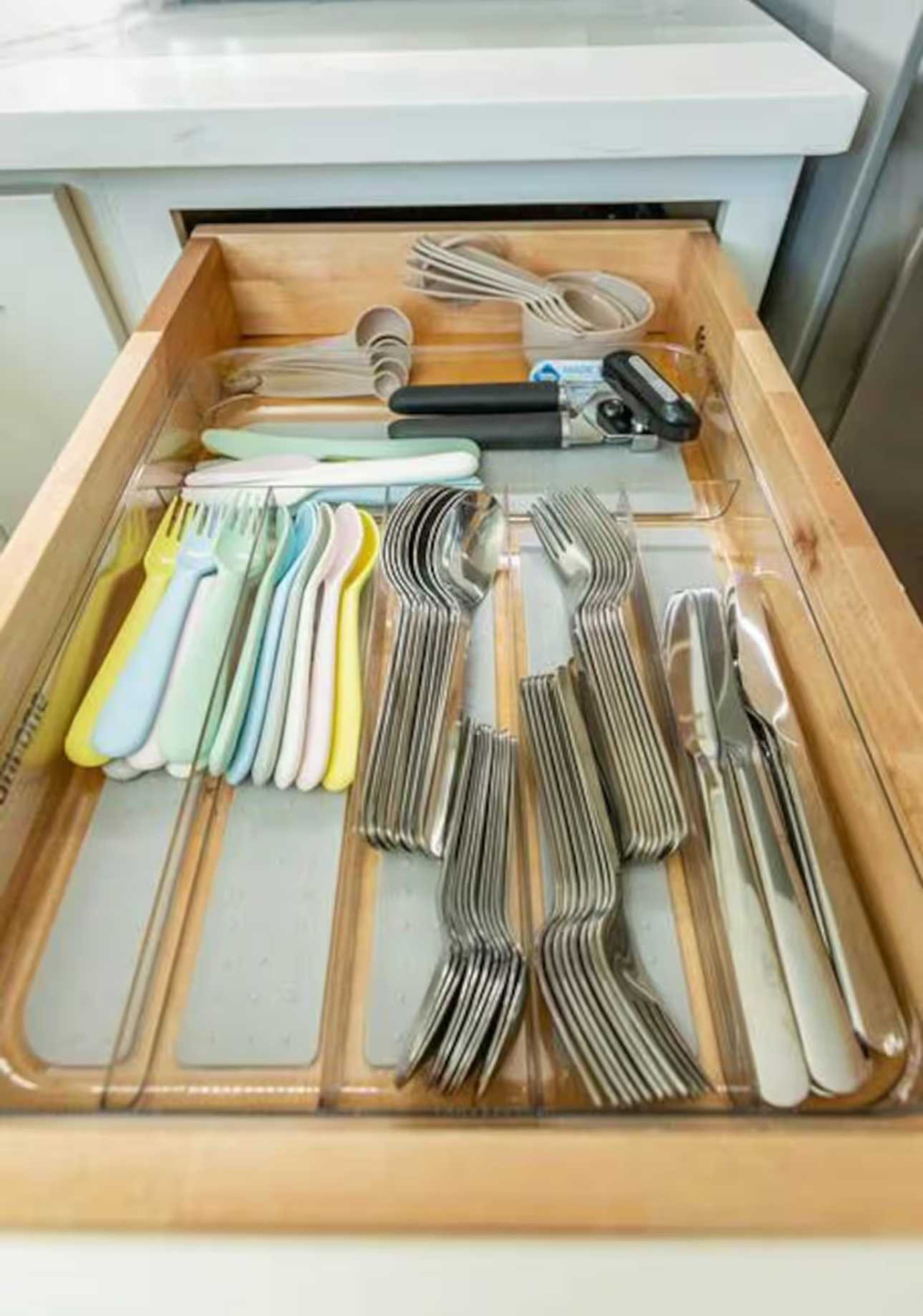 A drawer with utensils neatly organized in compartments.