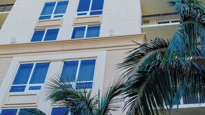 Un hotel alto de varios pisos con fachada color beige, ventanas grandes y balcones.