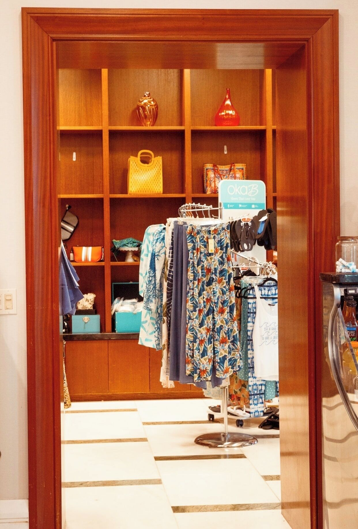 A wooden wardrobe with multiple shelves, a hanging rack, and a small table with a lamp.