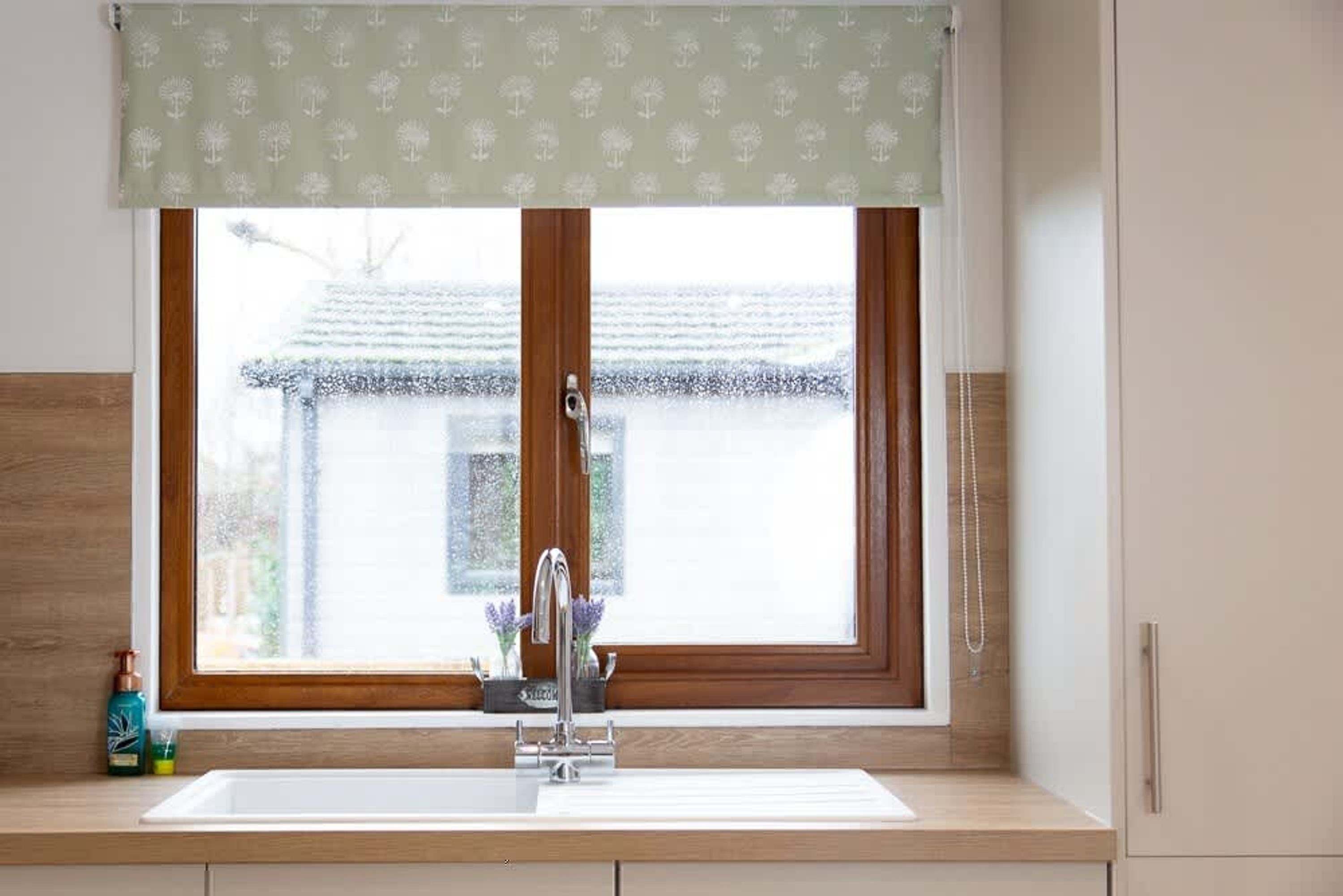 A kitchen with a window, a sink, and a faucet.