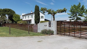 A gated property with a white building, a tall tree, and a well-maintained lawn. - Memento Agriturismo (Cervia)