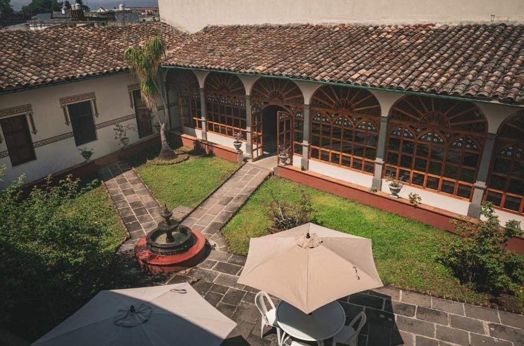 A courtyard with a tiled roof, a fountain, and outdoor seating.