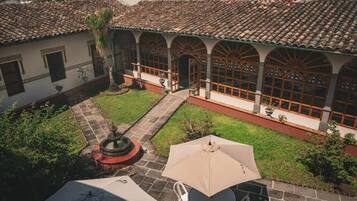 A courtyard with a tiled roof, a fountain, and outdoor seating.