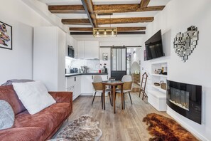 Un salon moderne avec un canapé rouge, une table basse et une cheminée.
